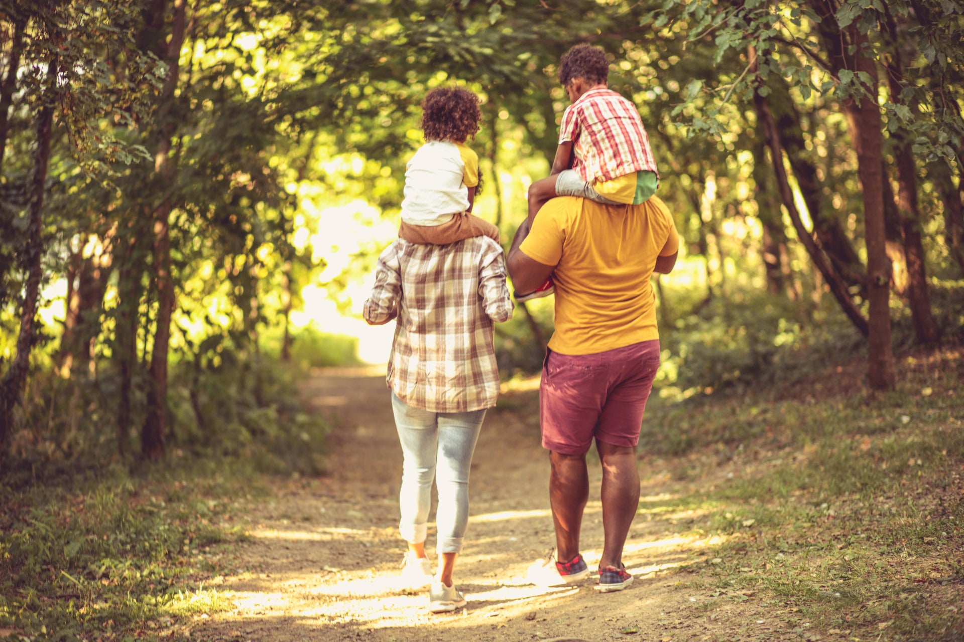 People walking with children on their shoulders