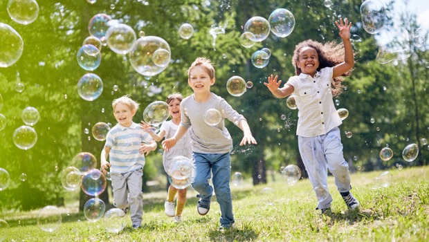 Young kids playing with bubbles outdoors