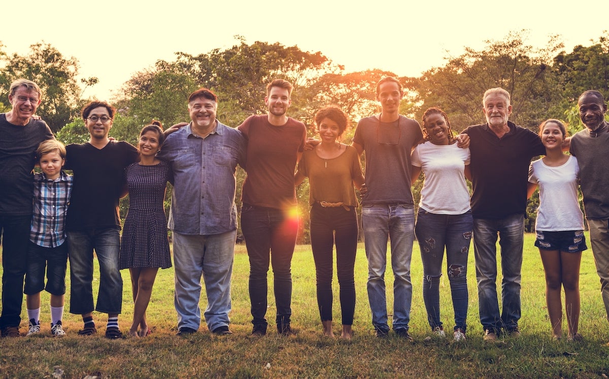 team standing arm in arm in field