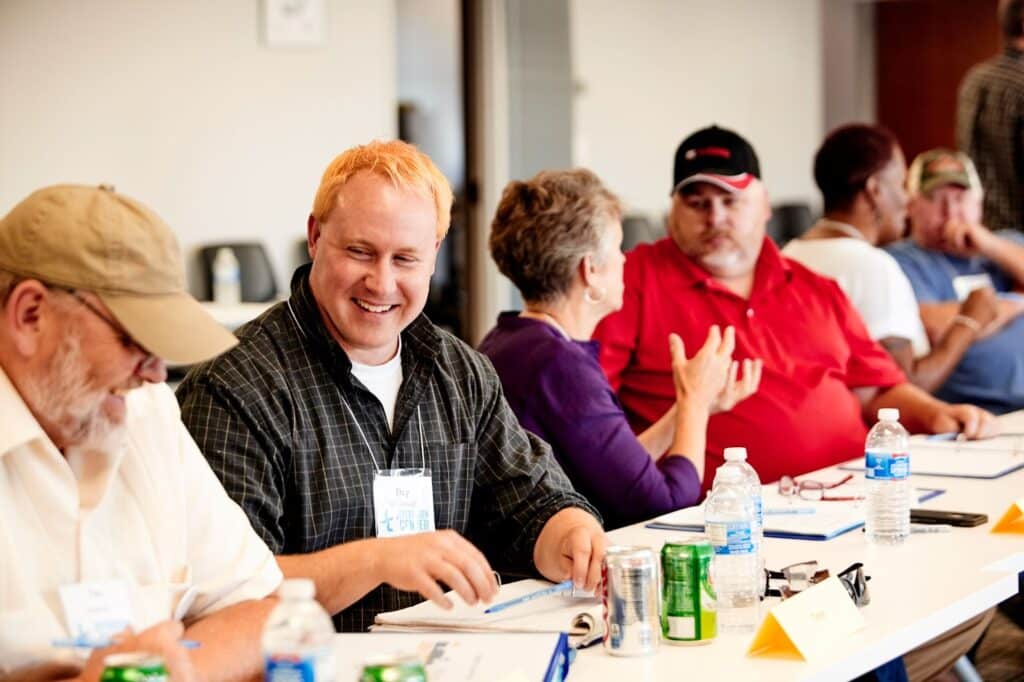 People smiling at the table with notepads and pens