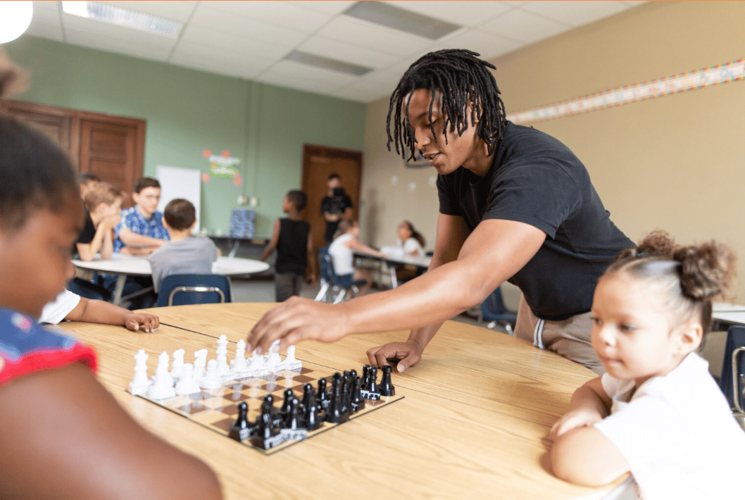 Man playing chess with two children