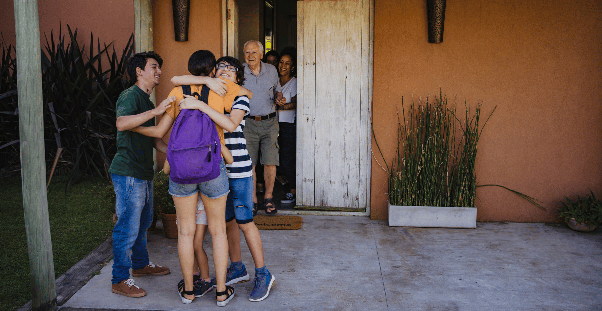 Image of young adults hugging while older adults look on