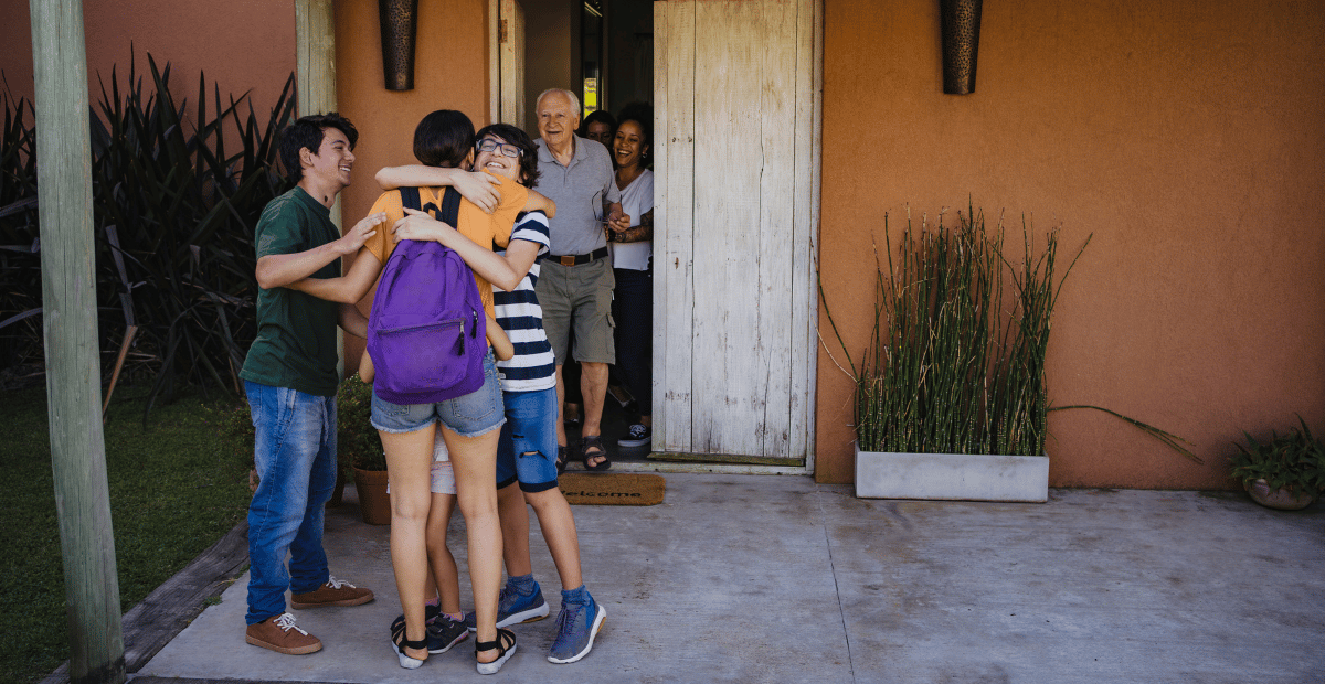 Young adult being welcomed home with hugs and excitement