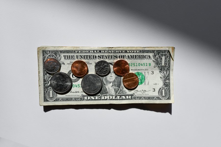 coins over a one dollar bill.