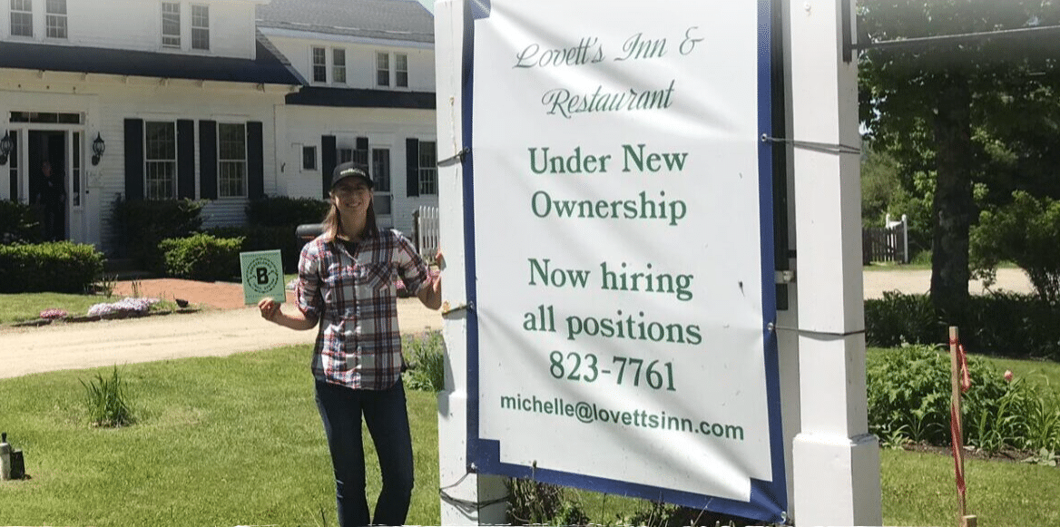 Local owner standing next to Under New Ownership sign