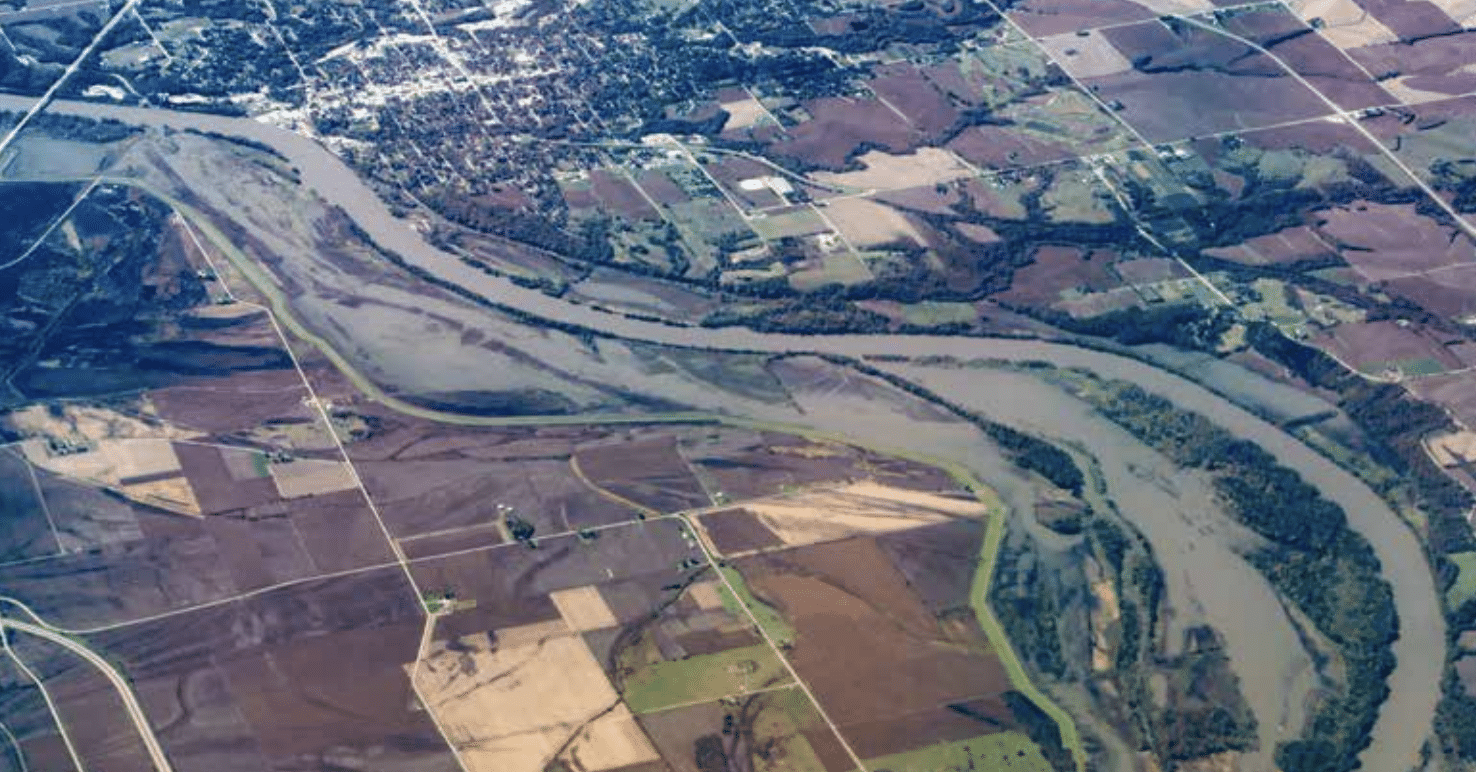 Aerial view of a river winding through agricultural fields in rural area.