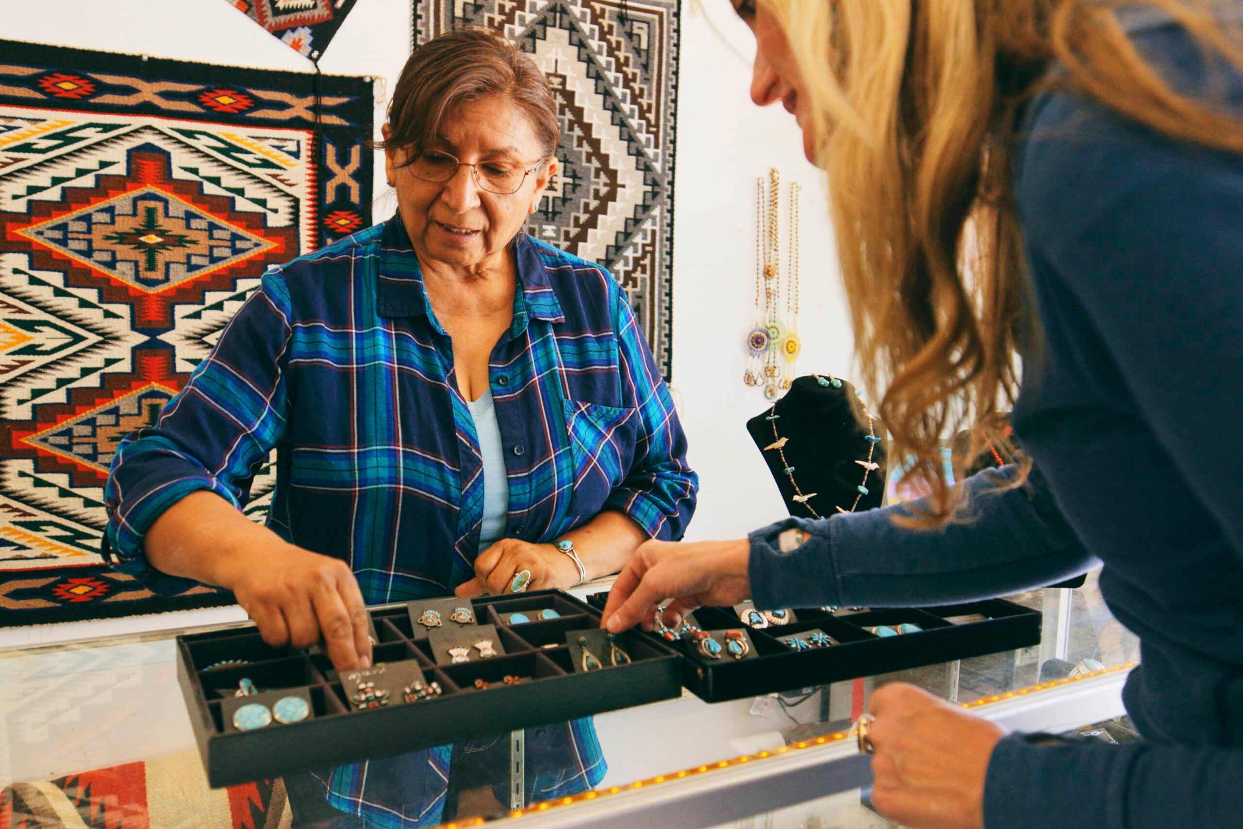 A female Indigenous Navajo small business owner at work in her jewelry shop.