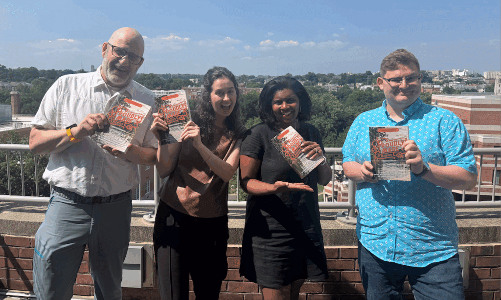Aspen CSG staff pose with Ta's book, Proudly Made. 